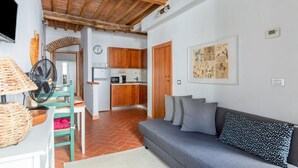 A compact living space with a kitchen, a dining area, and a sofa. - GuestHost - Boboli Gardens Lovely Apartment (Firenze)