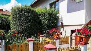Un bâtiment blanc avec une enseigne indiquant « 15A » et une clôture en bois dont les poteaux sont surmontés de décorations rouges.