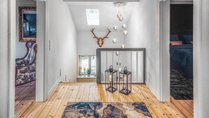 A hallway with wooden flooring, a rug, a mirror, a deer head decoration, and hanging spherical lights. - 3 bedroom beautiful home in Wartenberg (Wartenberg)