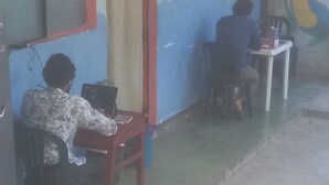 Una habitación con un escritorio y una silla, una computadora y una pequeña mesa con una silla.