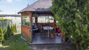 Un área de estar al aire libre cubierta con una mesa y sillas, una scooter y una bicicleta.