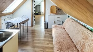 Un acogedor loft con comedor, kitchenette y sofá.