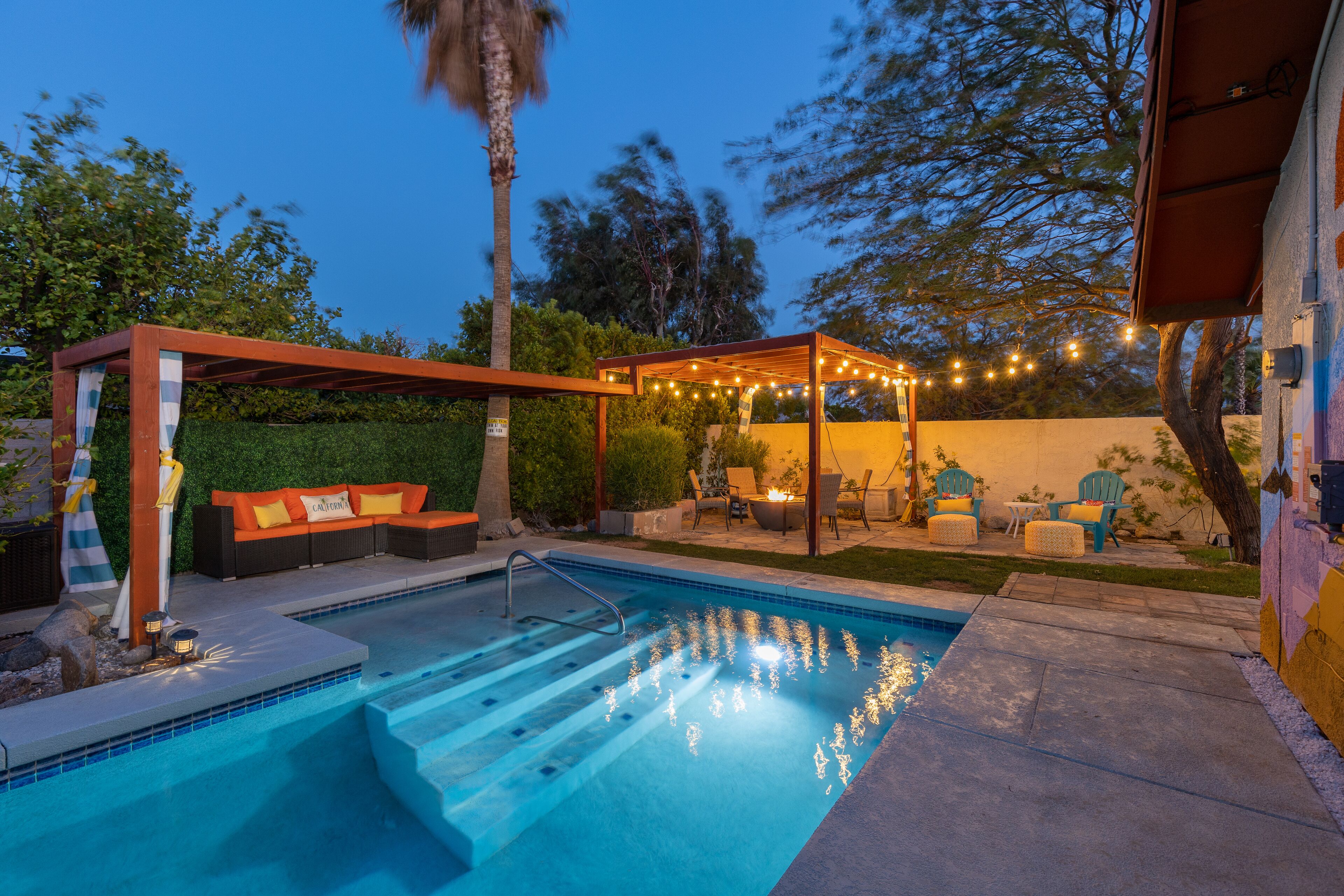 A swimming pool with a wooden deck and outdoor seating area.