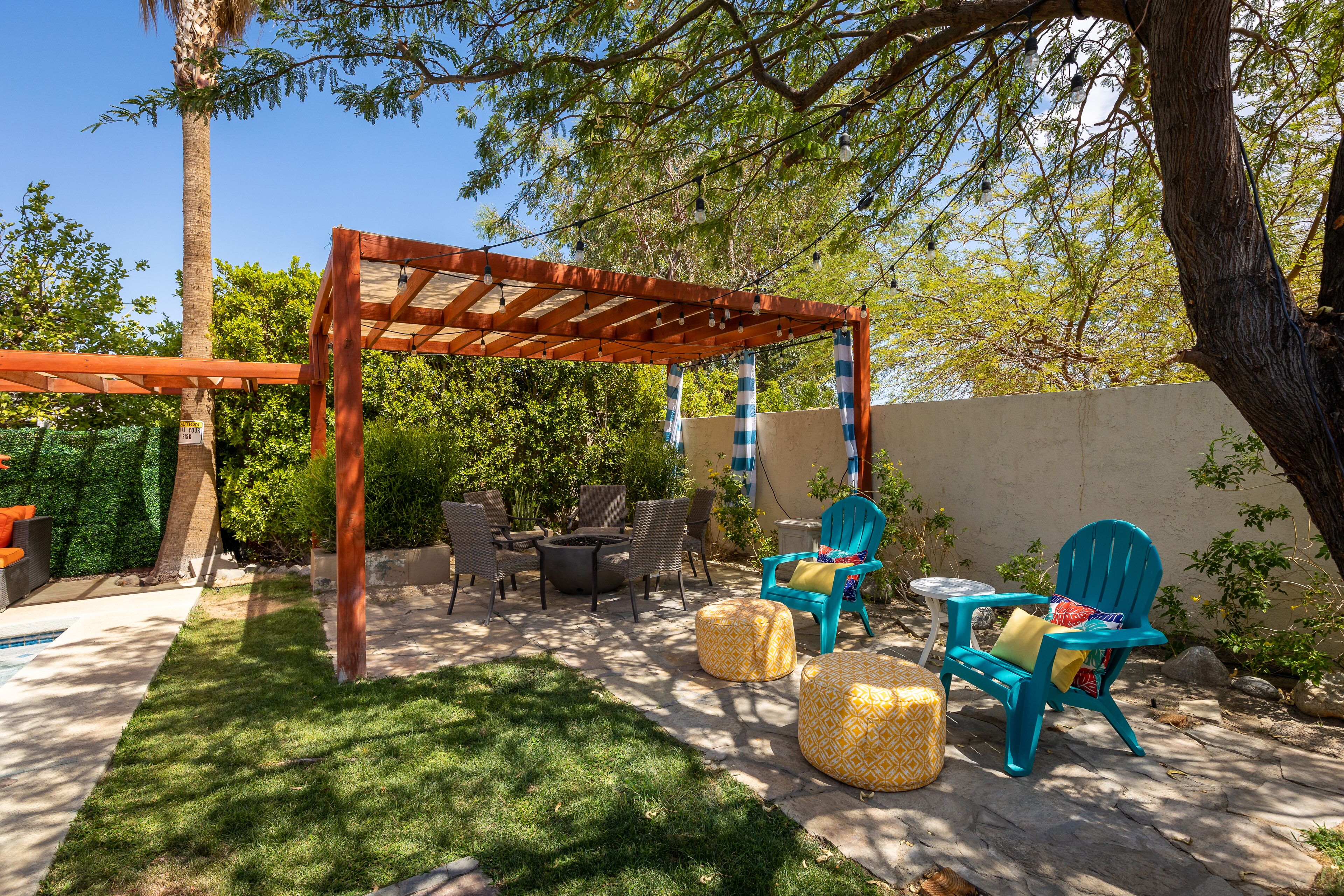 A patio with outdoor furniture, a pergola, and a fire pit.