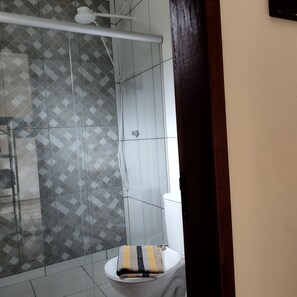 Chuveiro, toalhas de banho, papel higiênico 