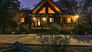 Un chalet doté d’une véranda bien visible à l’avant, d’une façade en bois et d’une entrée bien éclairée.