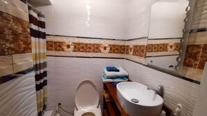 A bathroom with a toilet, sink, and mirror. - Casa de Fabrizio en Cusco, Ideal Para Familias (Cusco)