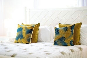 A bed with white bedding and two decorative pillows with leaf patterns. - Moonflower Villa: Luxe Oasis in Sunset Crest, Holetown (Sunset Crest)