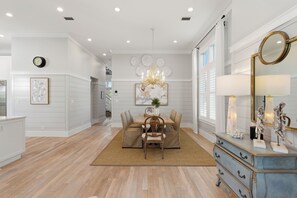 A dining area with a chandelier, a dining table, and chairs.
