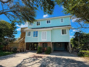 A two-story building with a porch, a staircase, and a garage.