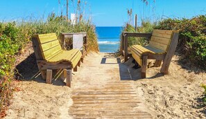 A wooden pathway leading to beach chairs on a sandy beach with the ocean in the background. - Beach Haven - Enjoy beautiful views from this light and airy home! (Duck)
