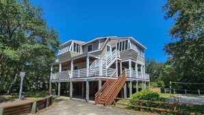 A multi-story building with a wooden staircase leading to the upper levels. - Fair Winds - Oceanside home w/Private Pool - Dogs Allowed! (Southern Shores)