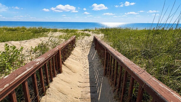 A sandy beach path with wooden railings leading to the ocean. - 12 ON 12 - Sip coffee and take in the beautiful ocean views with this oceanfront home! (Southern Shores)