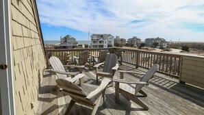 A wooden deck with Adirondack chairs overlooking a beach and houses. - Knock On Wood - Directly across from the beach access with terrific ocean views (Duck)
