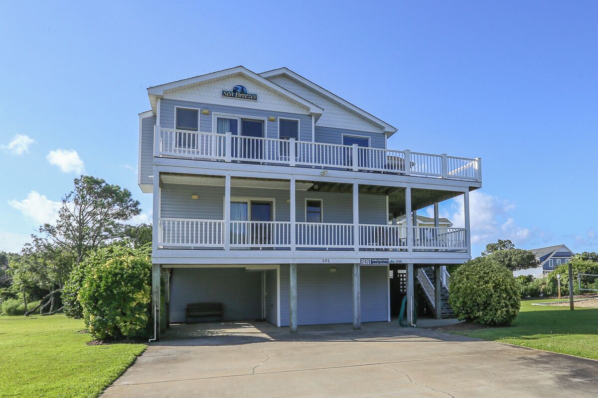 A two-story building with a balcony on the upper floor and a garage on the ground floor.