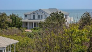 A two-story house with a large porch and a view of the ocean. - Star Gazer - Wake up to an Outer Banks sunrise from this luxurious oceanfront home (Duck)
