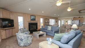 A spacious living room with a fireplace, a television, and a dining area with a table and chairs.