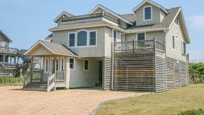 A two-story house with a covered porch, a fenced deck, and a driveway. - Carolina Dreamin' - Oceanfront 5 BR Home with community pool - Dogs Allowed (Duck)
