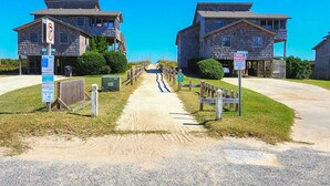 A pathway leading to a row of stone buildings with a no parking sign and a private property sign. - “Surf & Sound” is the best of both worlds! Just steps away from the beach and Sound! (Duck)