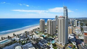 Un paisaje urbano costero con rascacielos, una playa y un cielo azul despejado.