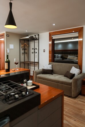 Cozy living space with a kitchenette, dining table, and comfortable sofa.