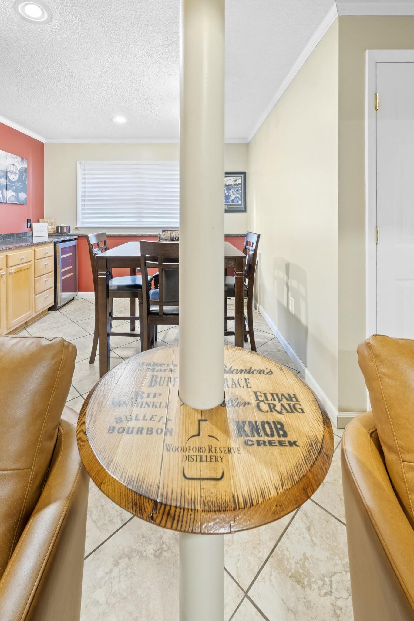 Un espace repas comprenant une table ronde en bois, des chaises et une colonne centrale.