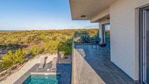 A balcony with a pool, chairs, and a view of the landscape. - Luxurious home in Mandre (Mandre)