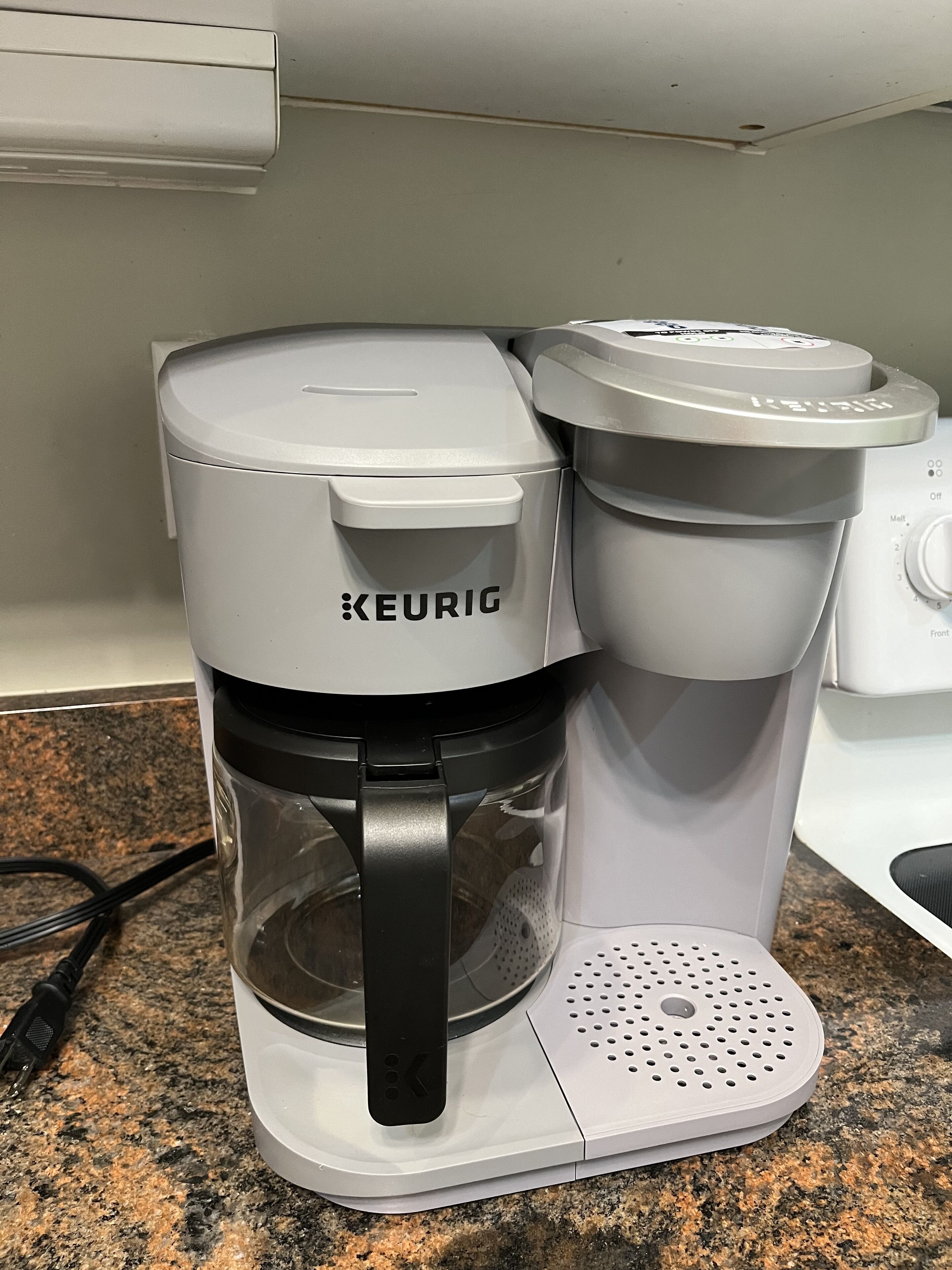 A Keurig coffee maker on a granite countertop.
