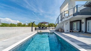 A modern house with a swimming pool, a covered patio, and a staircase leading to a balcony. - Lovely apartment in Sukosan (Sukosan)