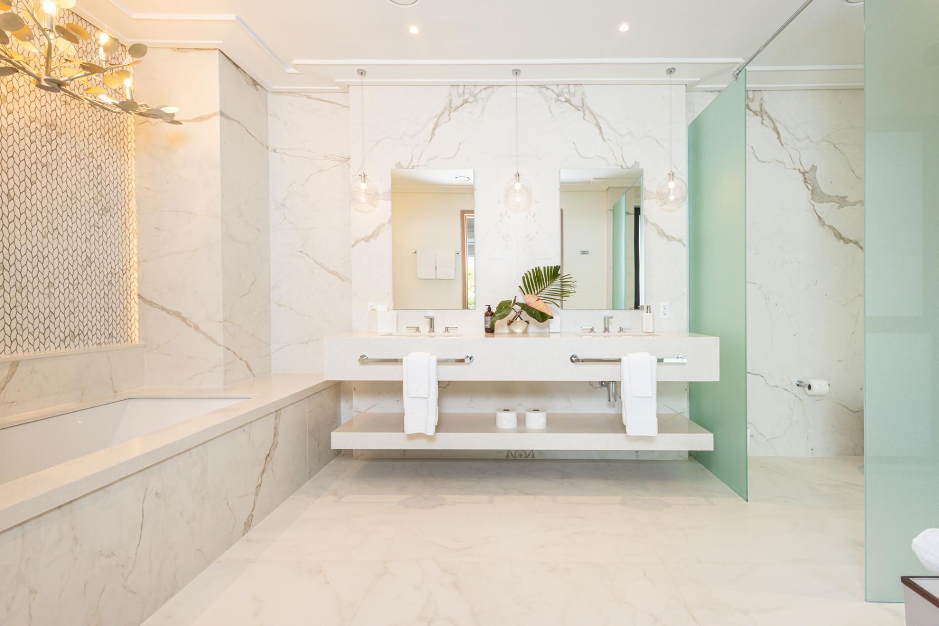 A modern bathroom with a marble vanity, double sinks, and a large mirror.