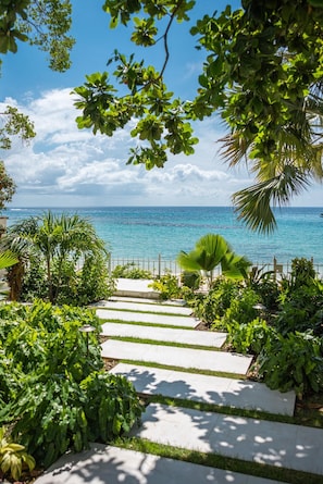 Stroll along the serene pathway to the beach, surrounded by lush tropical vegetation and the soothing ocean views.