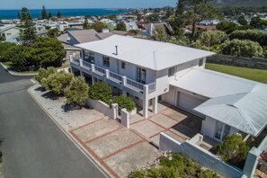 A modern two-story house with a balcony, a garage, and a driveway.