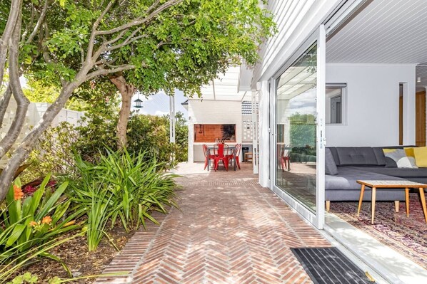 A modern house with a patio, a dining area, and a living room with a sofa and a coffee table.