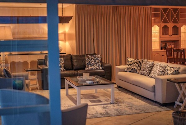 A living room with a sofa, armchairs, a coffee table, and a dining area with a table and chairs.