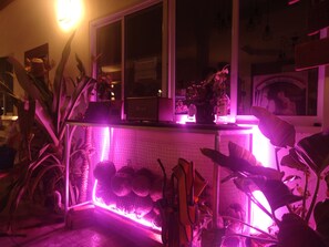 A room with a window, a white tiled wall, and a neon pink light. - BaanPaa Resort (Ban Pong)