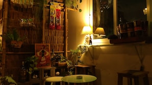 Una habitación acogedora con una pared de bambú, una mesa pequeña con una silla y una ventana con vistas al cielo nocturno.