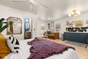 A modern bedroom with a bed, a desk, a sofa, and a kitchenette. - Luxe Studio Retreat - Close to DT & UT Austin (Austin)
