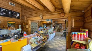 A wooden interior with a checkered floor, a counter with various items, and a display of canned goods.