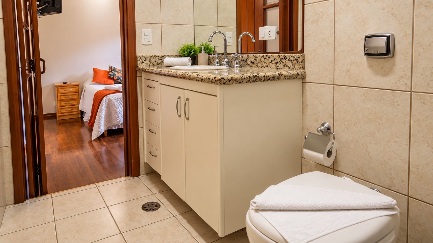 A bathroom with a toilet, sink, and cabinet.