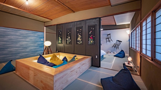 A traditional Japanese room with tatami flooring, a wooden bathtub, and sliding doors with floral designs. - Yumejuya (Yugawara)
