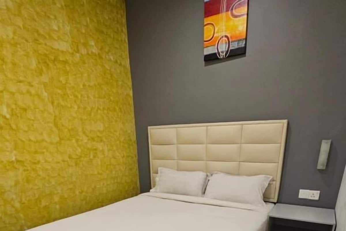 A bedroom with a bed, a nightstand, and a wall-mounted artwork.