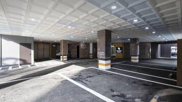 A parking garage with multiple levels, marked parking spaces, and a sign for 'Beyond Hotel'.