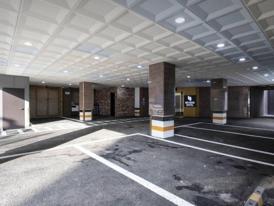 A parking garage with multiple levels, marked parking spaces, and a sign for 'Beyond Hotel'.