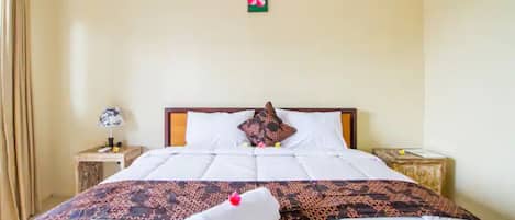 A neatly made bed with a patterned bedspread, a pillow, and a decorative pillow on a headboard.