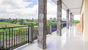 Ein geräumiger Balkon mit Blick auf eine grüne Landschaft und entfernte Gebäude.