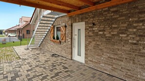 A brick building with a wooden beam ceiling, a white door, and a window with a wooden frame. - Holiday Home "Speicherhäuschen Maike" with Private Garden & Wi-Fi (Geeste)