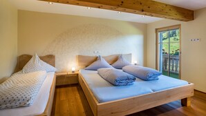 Een slaapkamer met een houten bed, twee nachtkastjes, een groot raam en een wand met een gebogen ontwerp.