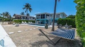 Un resort con piscina, palme e un'amaca.