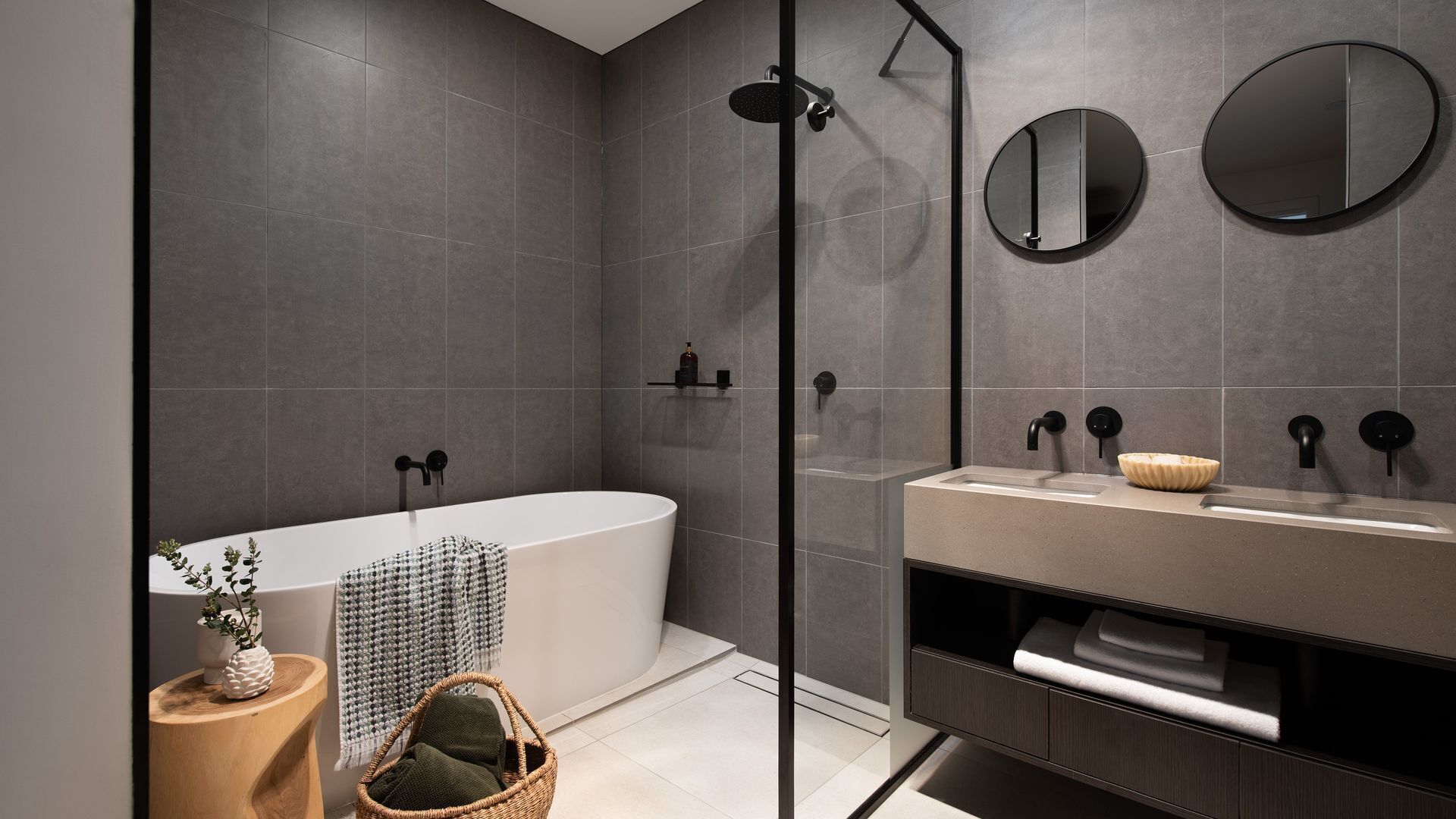 A modern bathroom with a freestanding bathtub, a glass-enclosed shower, and a vanity with a mirror.
