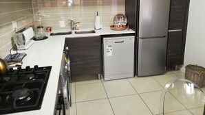Eine moderne Küche mit einem Edelstahl-Kühlschrank, einer Spülmaschine, einem Herd und einem Waschbecken.